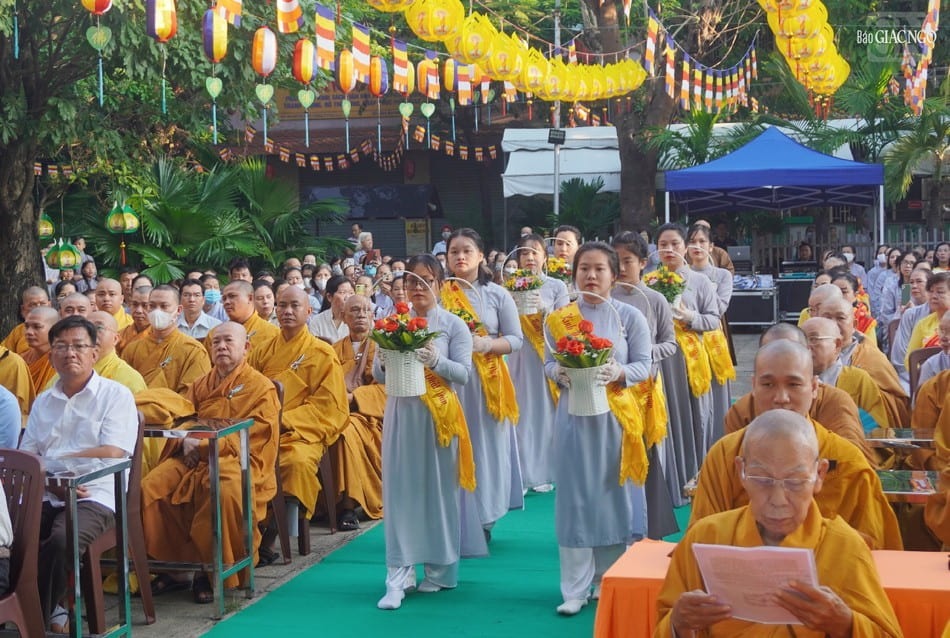 Buddhist devotees carrying flowers during a Vesak ceremony in Vietnam